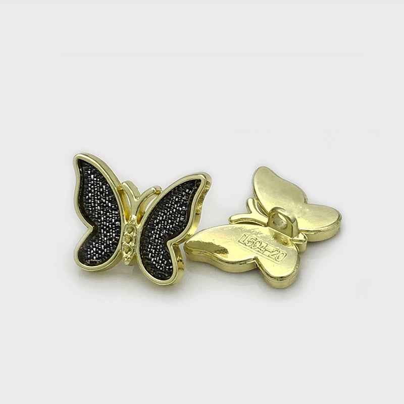 Black 3D butterfly metal button with speckled dark inlay and gold-tone edging