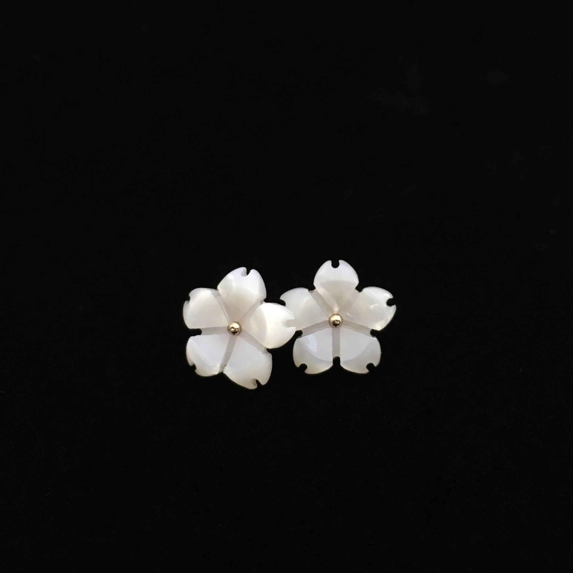 Zwei weiße blumenförmige Resin-Knöpfe mit goldfarbener Öse, spitze Blütenblätter