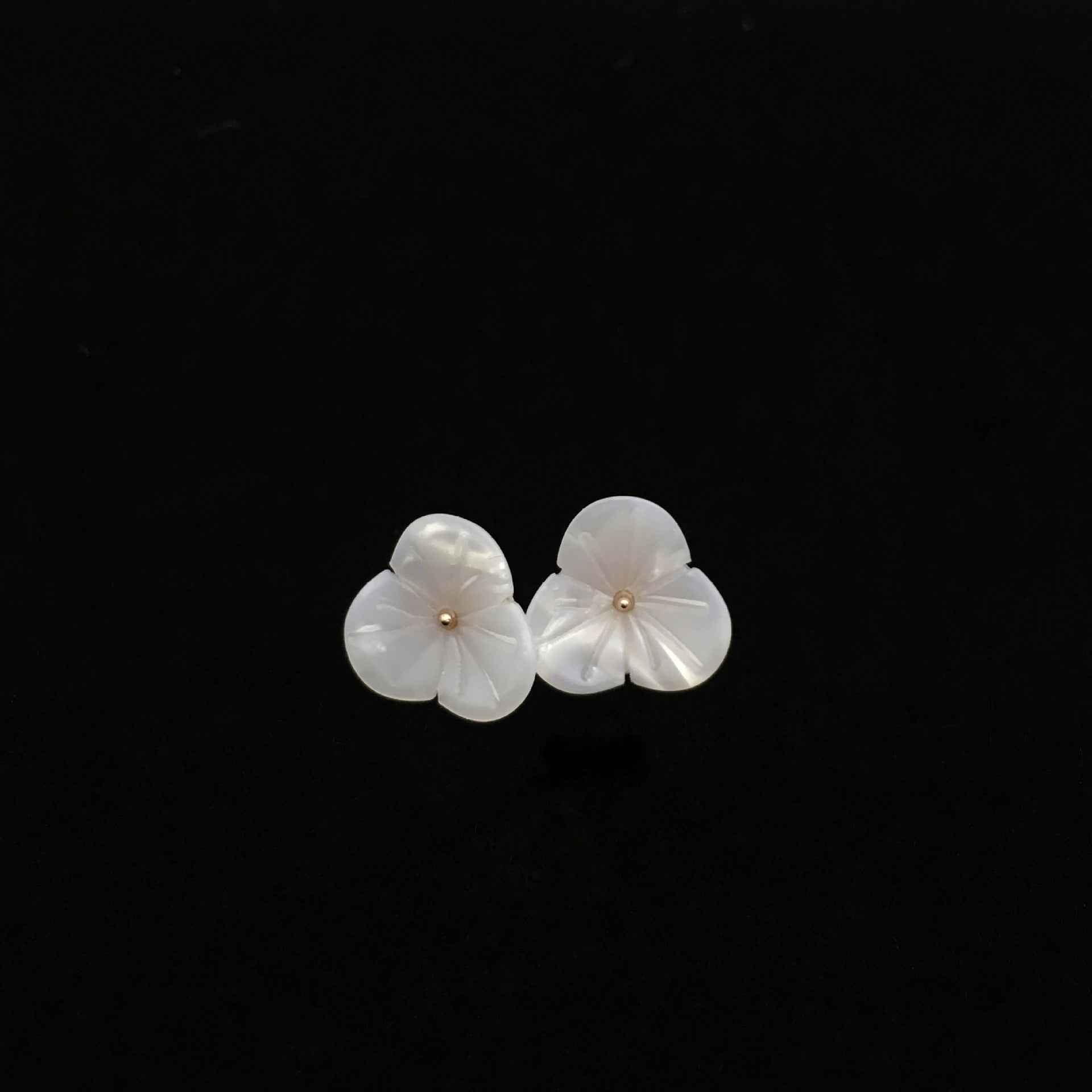 Zwei weiße blumenförmige Resin-Knöpfe, goldfarbener Mittelpunkt im Zentrum