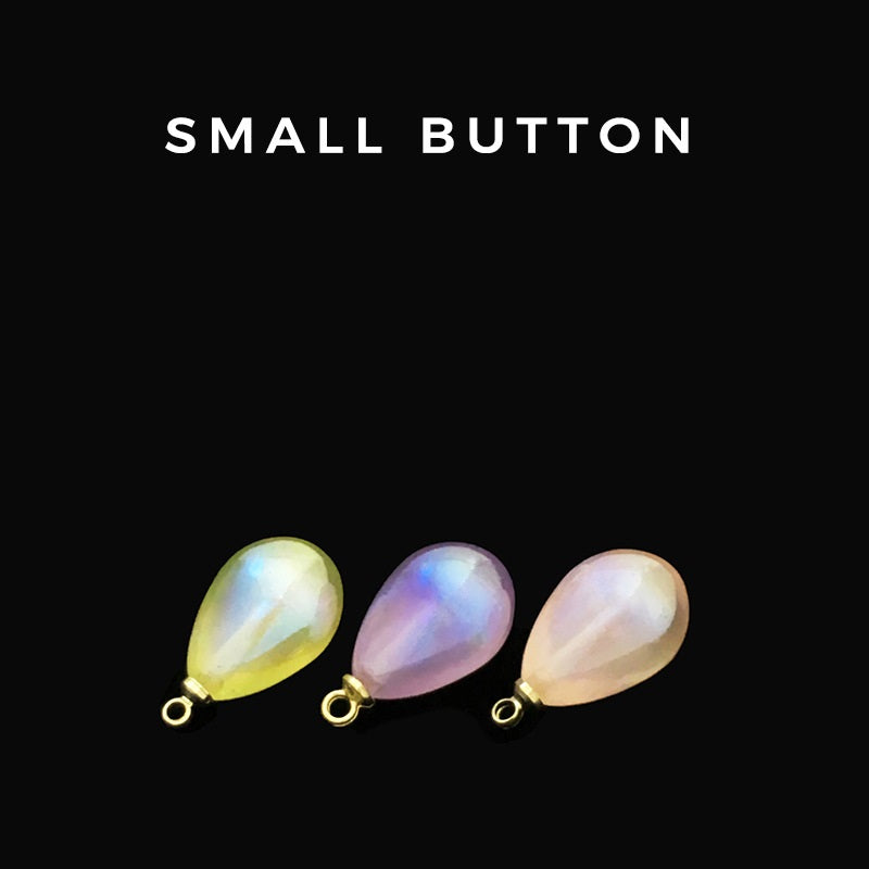 Set of iridescent teardrop buttons in yellow, purple, and pink with metal loops