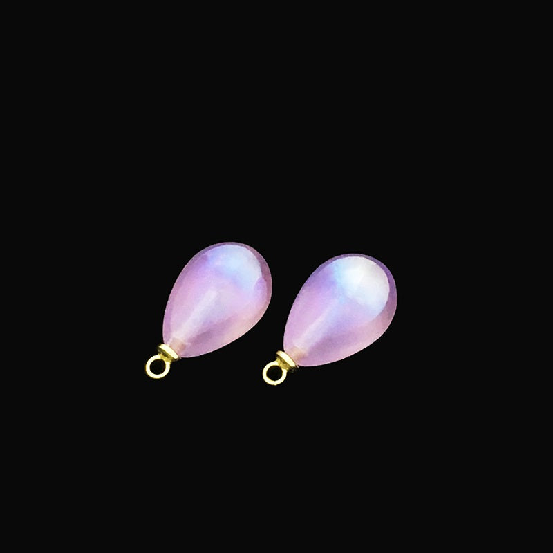 Two iridescent purple teardrop buttons with metal loops for sewing
