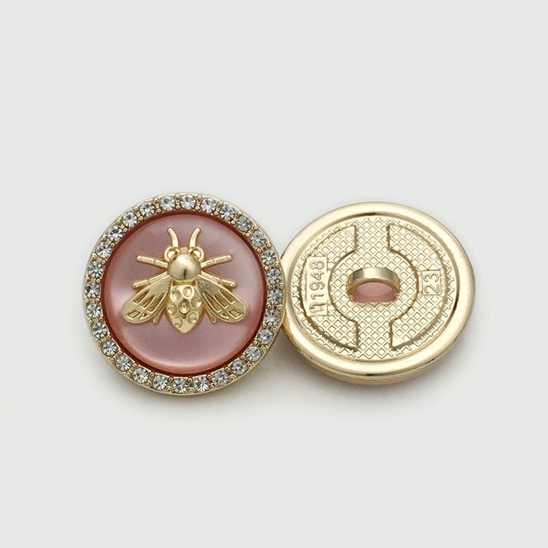 Pink bee metal button with rhinestone border; shows front and gold-toned back