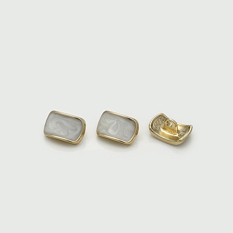 Rectangular shirt buttons: white oil-spotted fronts with gold metal backs