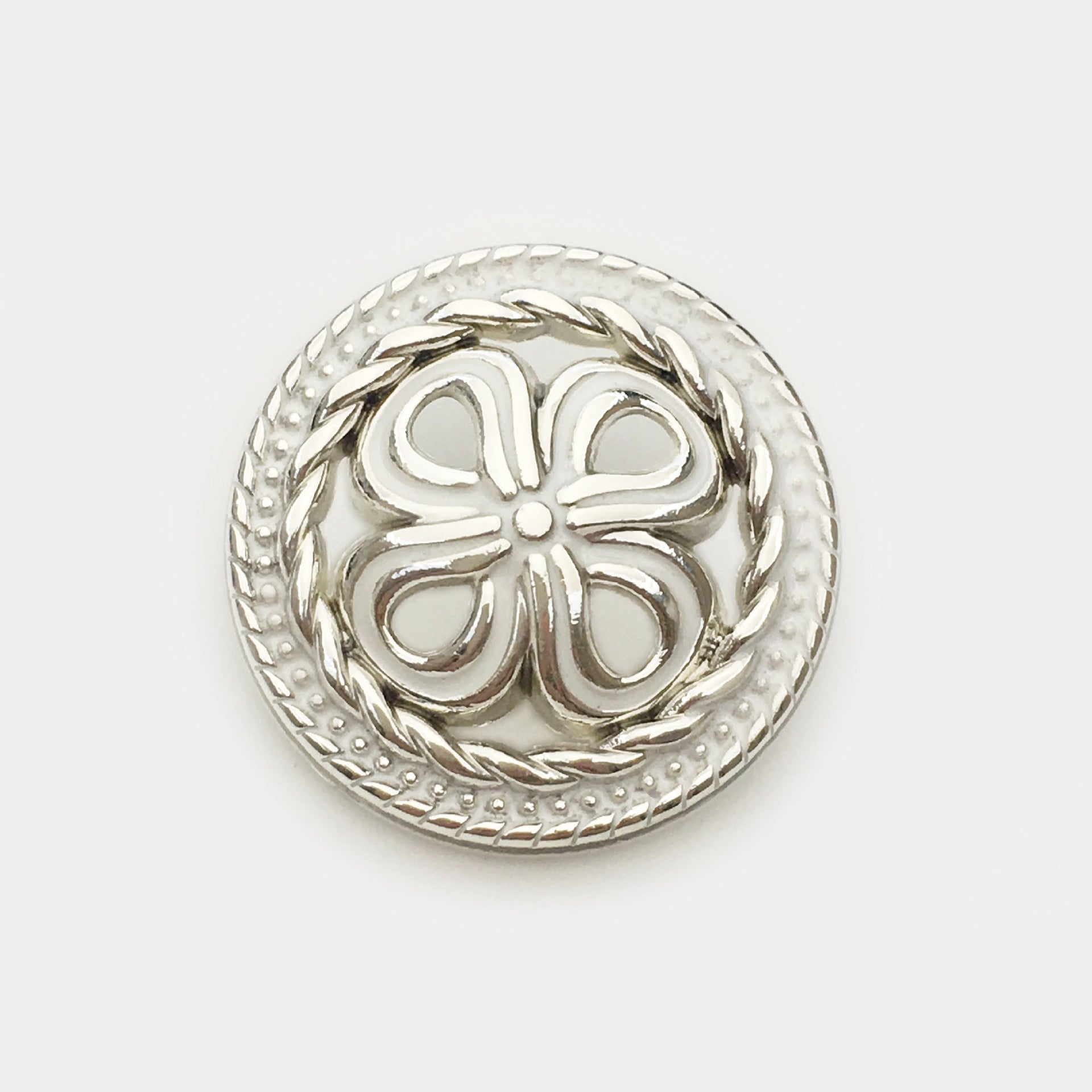 Silver hollow four-leaf clover metal button with white center and braided rim