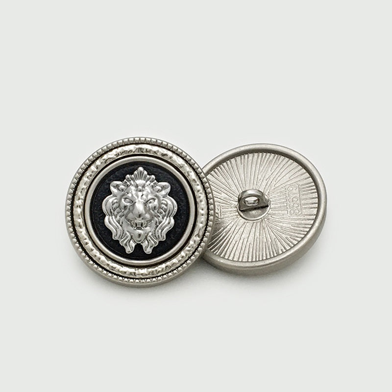 Silver lion-head round metal button with black center, showing back shank