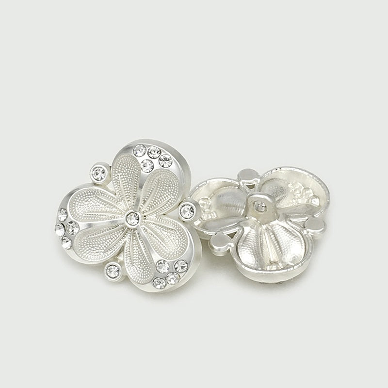 Two silver rhinestone flower metal buttons shown from the back and front views
