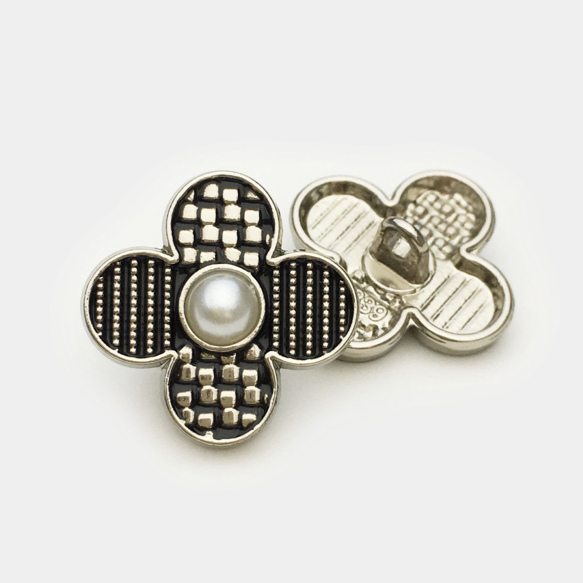 Silver-tone four-leaf clover metal button with faux pearl center; reverse plate visible
