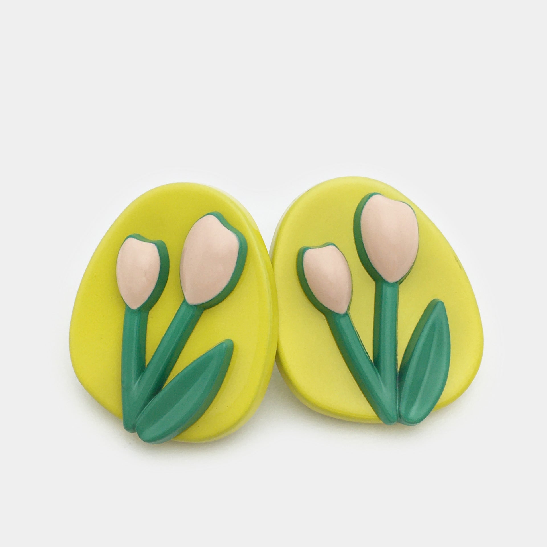 Oval tulip metal buttons, bright yellow faces with cream tulip petals and green leaves