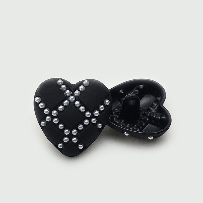 Black heart button with pearl-look stud X design; shows underside shank