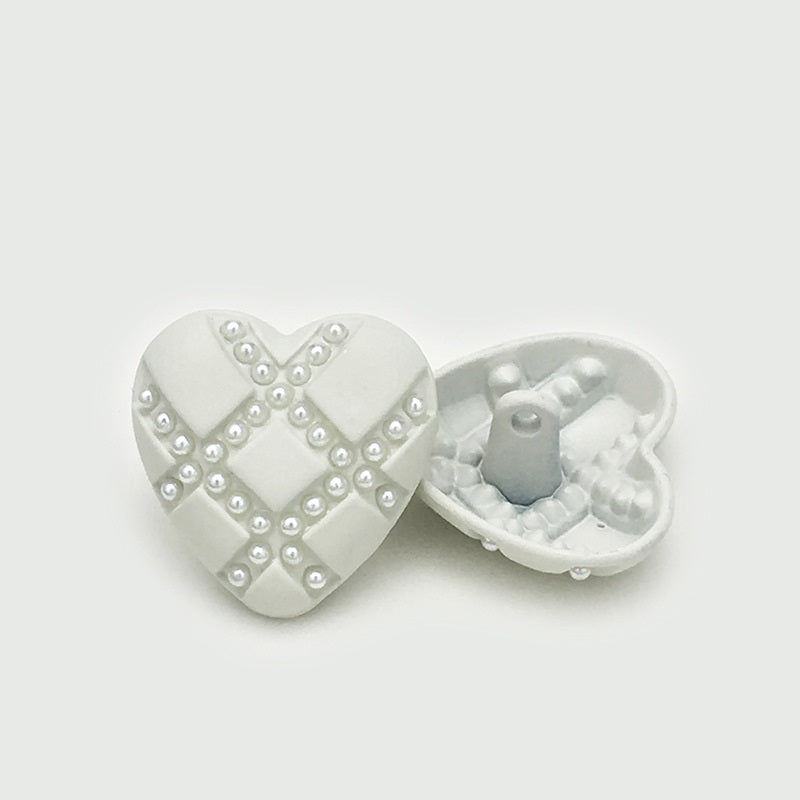 White heart button with pearl-look stud X design, side view of metal shank