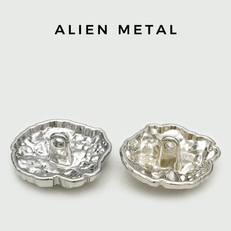 Oversized silver metal button, ridged edges, shank hole visible, back view