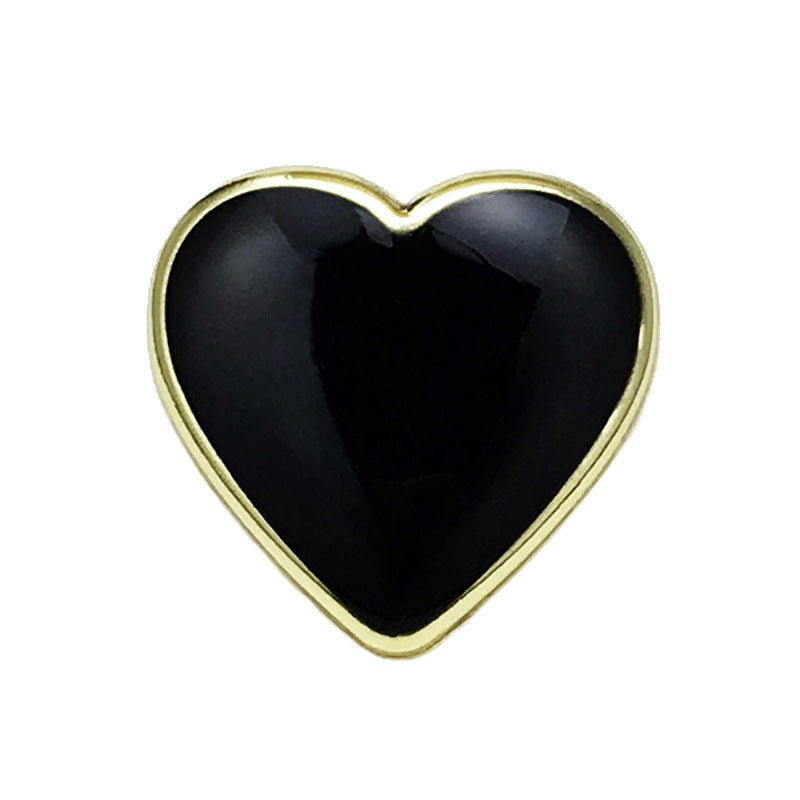 Heart-shaped metal button: black center, gold-tone rim.