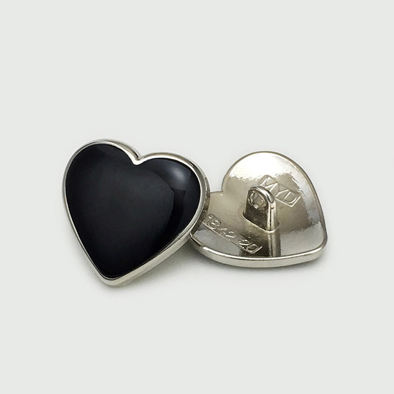 Heart button with black face; silver-tone rim and visible metal shank on back.