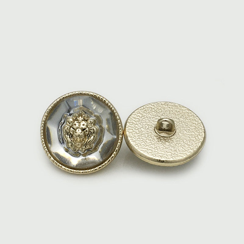 Lion head resin metal button, silver-tone front with gold rim; back shows shank