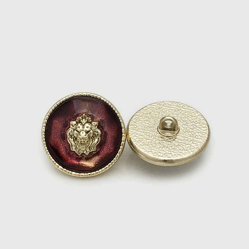 Lion head resin metal button, red/maroon front with gold rim; back shows shank