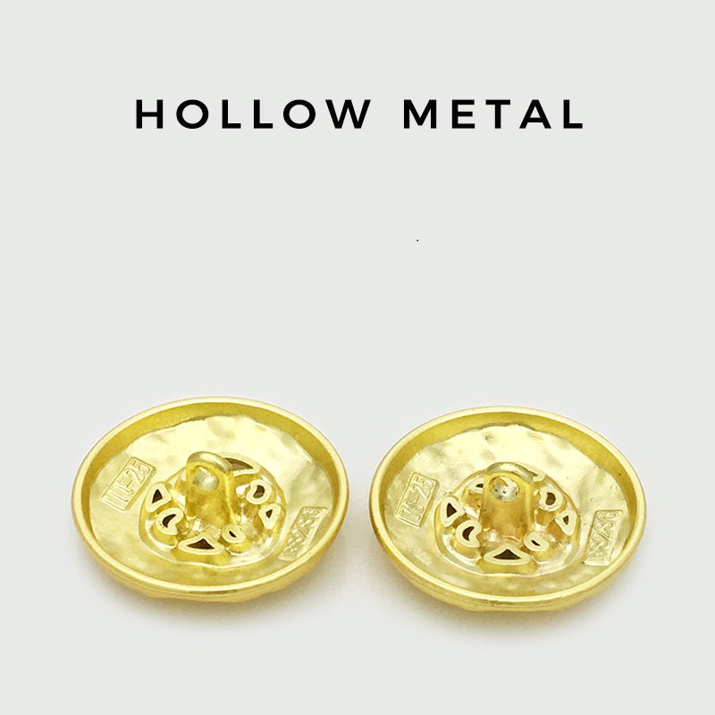 Pair of gold hollow metal buttons with ornate engraved pattern on the backs