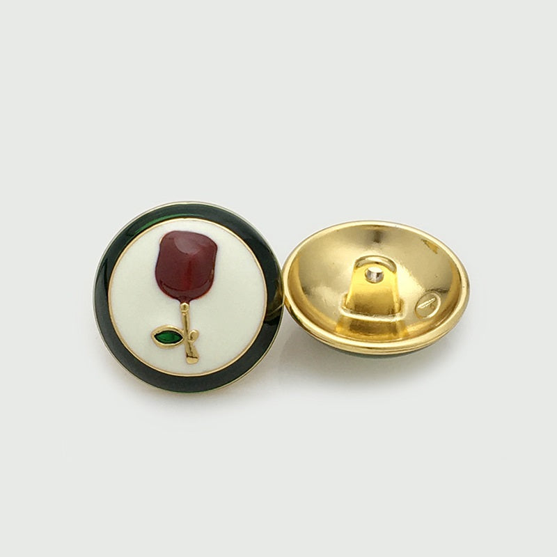 Par de botones: frente con rosa burdeos y hoja verde; reverso dorado con vástago