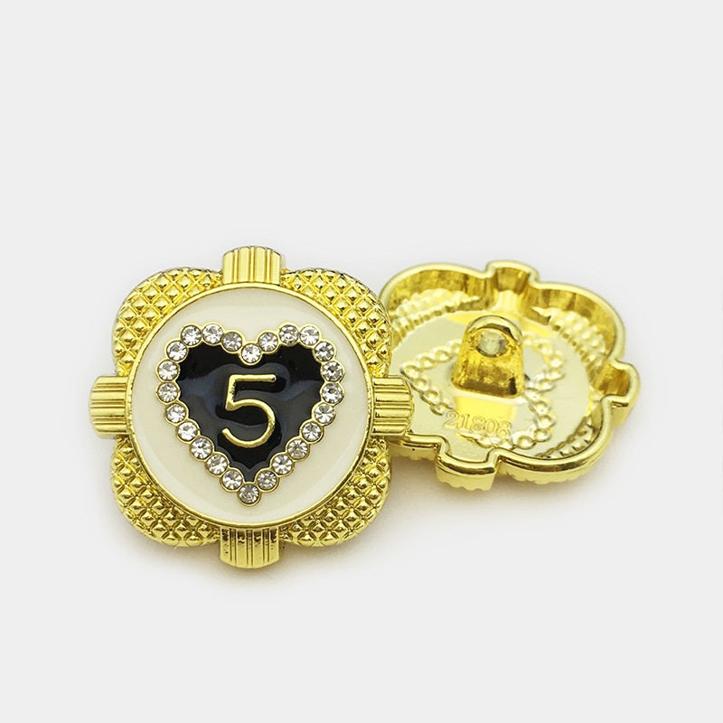 Heart-shaped gold metal button front with rhinestone frame; visible back with posts