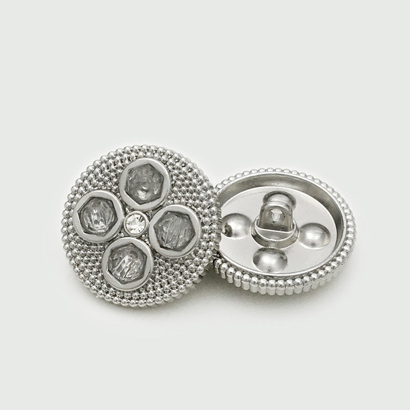 Silver four-leaf clover diamond metal button with pin back and faceted inset stones.