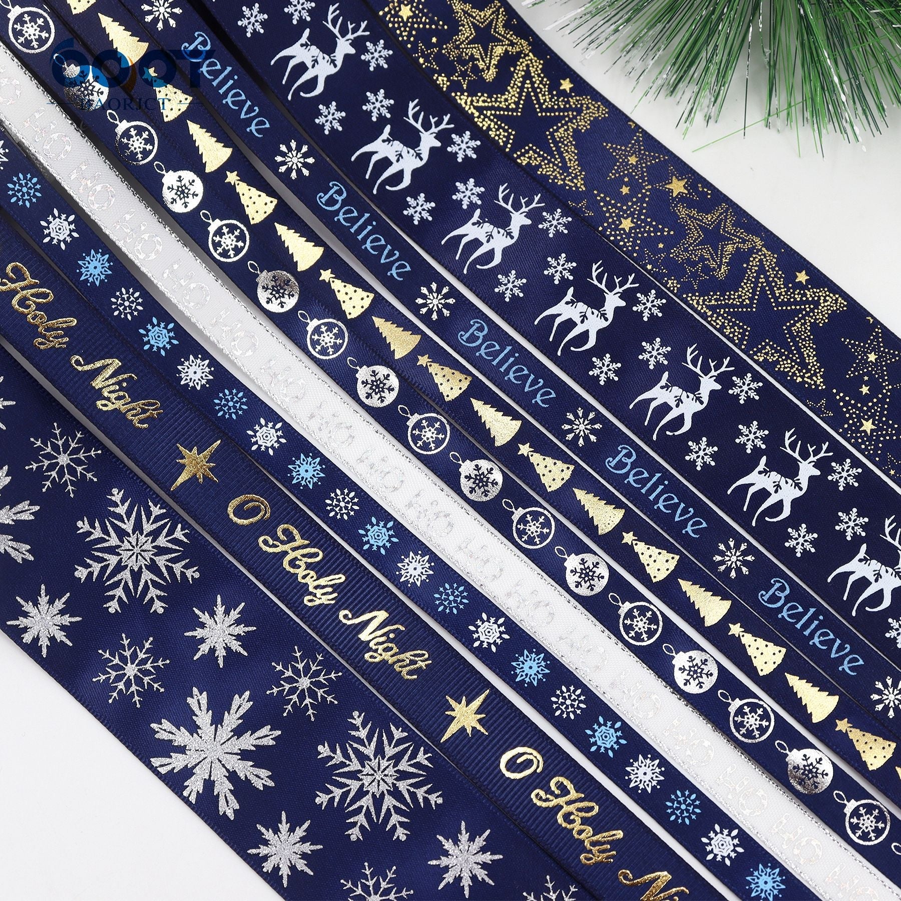 Navy Christmas ribbon close-up with “Believe” script, reindeer, snowflakes, and gold stars