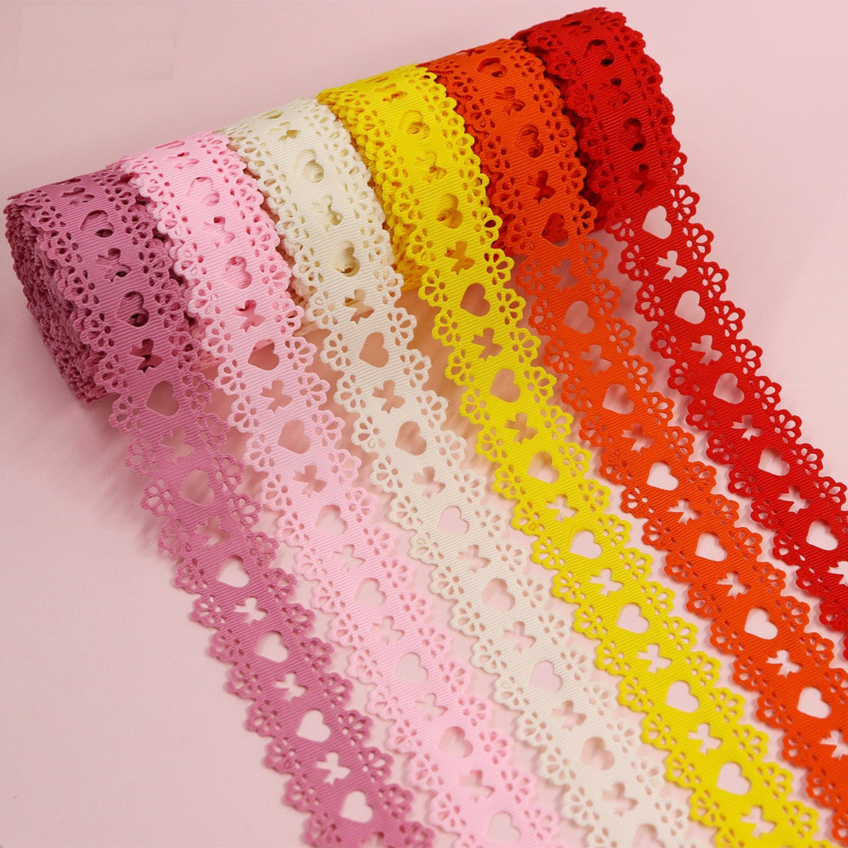 Heart-cutout grosgrain ribbon rolls with hearts in pink, white, yellow, orange, red
