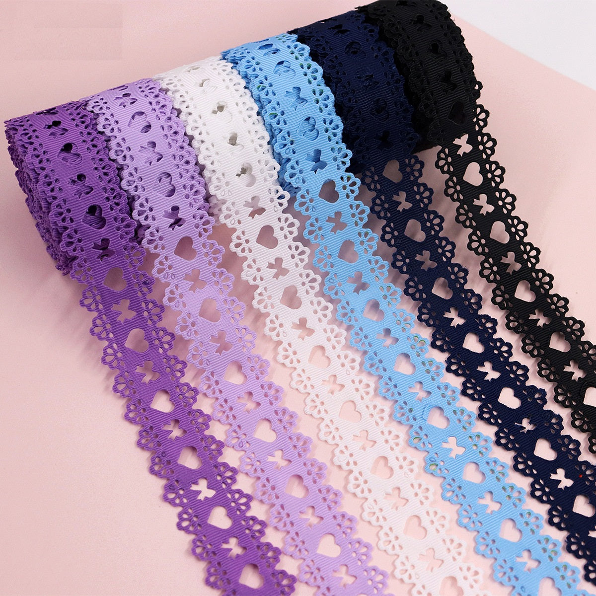 Heart-cutout grosgrain ribbon rolls in purple, white, light blue, navy, and black