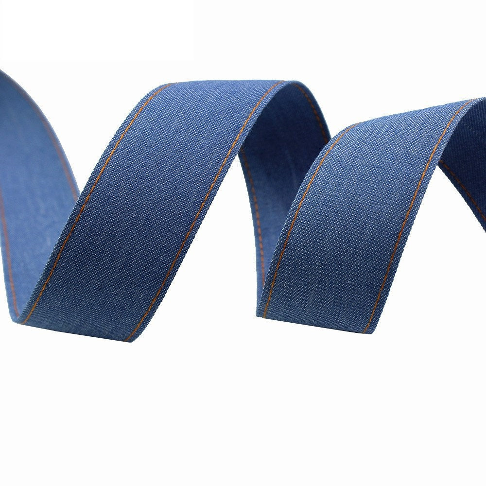 Blue denim fabric ribbon with orange edge seam, rolled ribbon end view