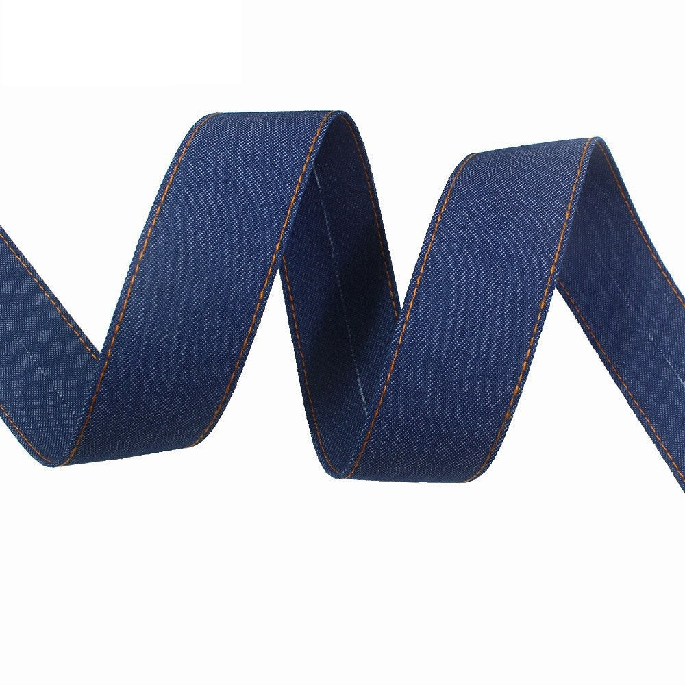 Denim fabric ribbon in dark blue with orange edge stitching, wavy folded strip
