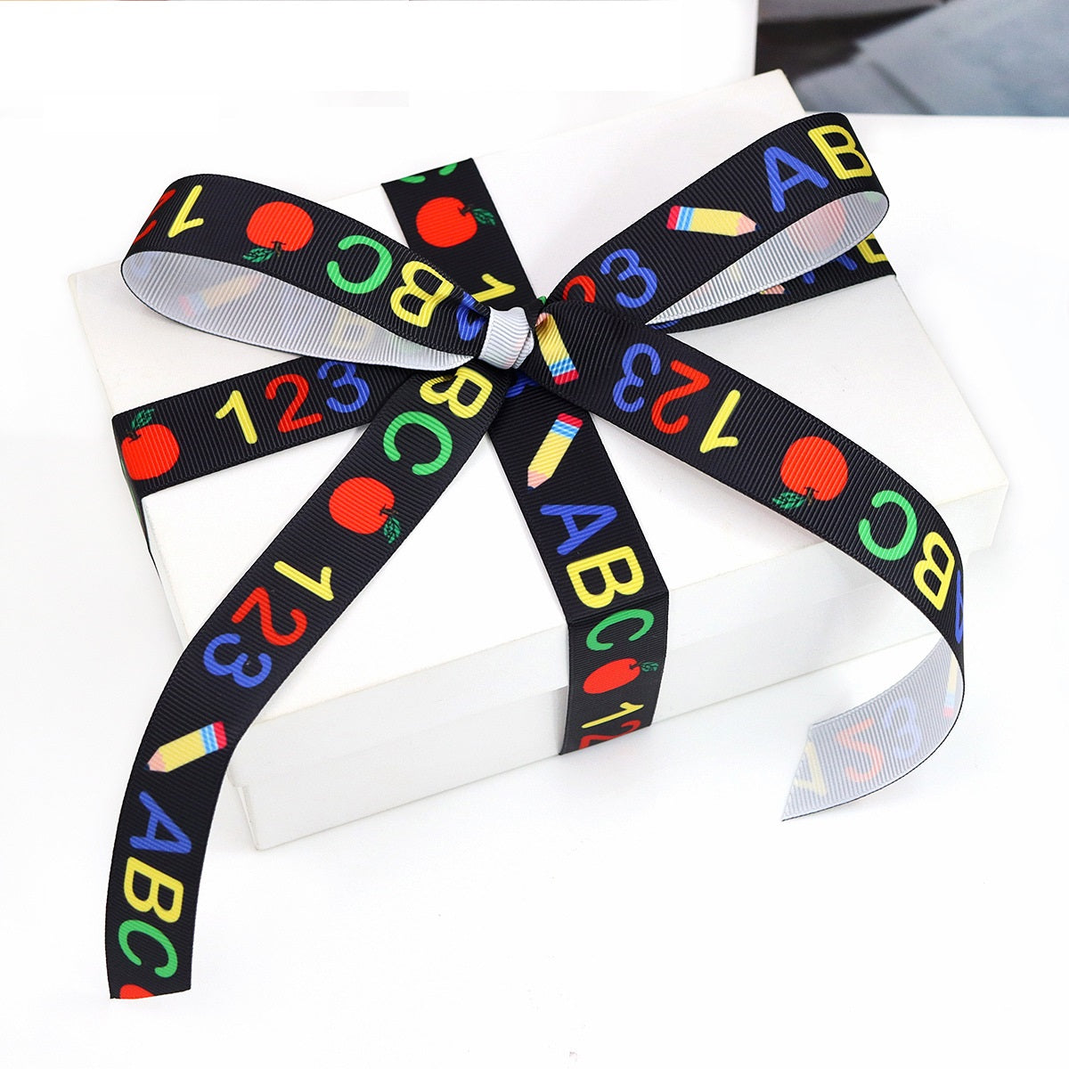 22-mm-Geschenkband mit ABC/Nummernprint, große Schleife auf verpacktem Geschenk