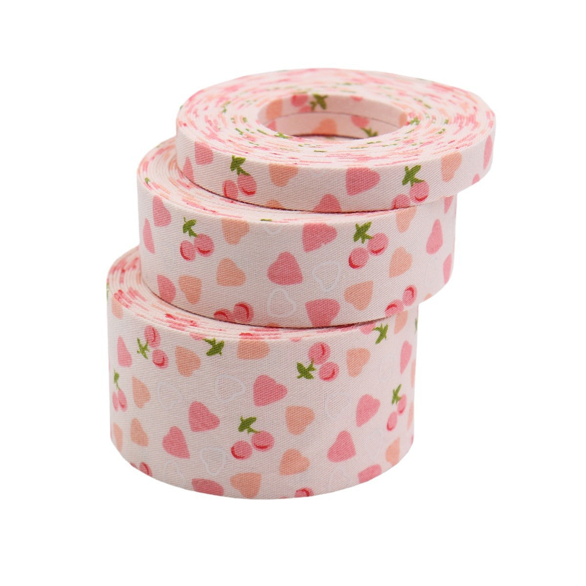 Rolled pink cherry and heart bias tape ribbon, stacked for craft use