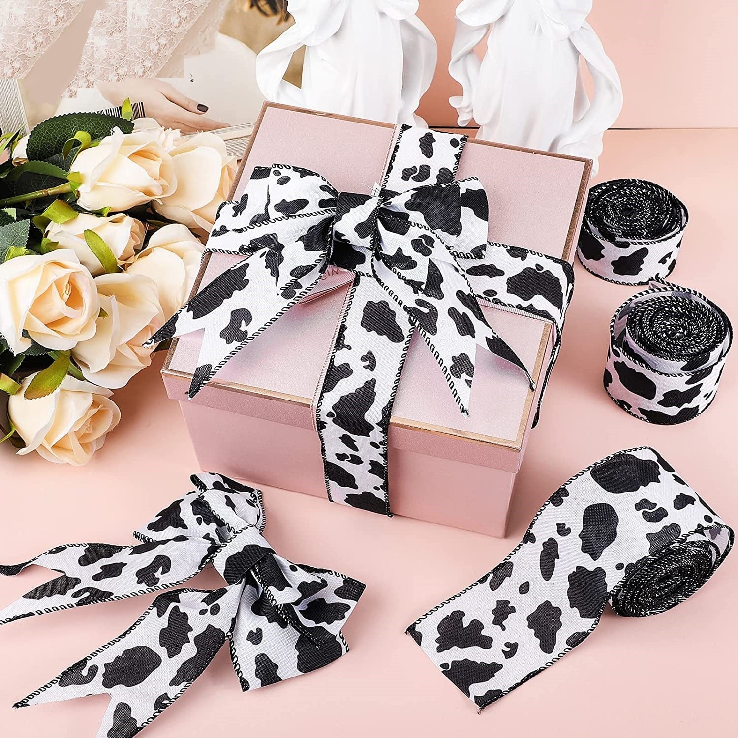 Cow print wired hem tape bows on gift boxes with ribbon spools, black and white