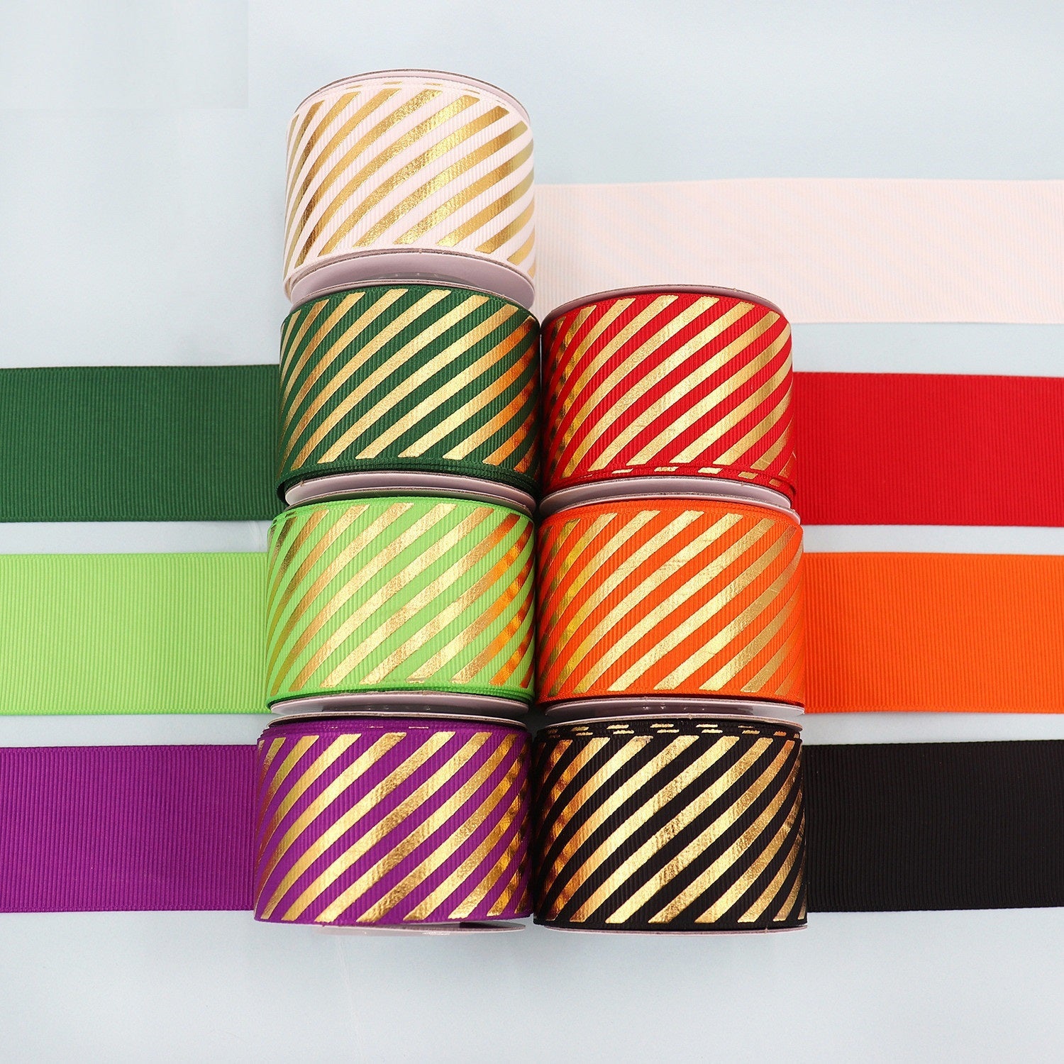 Stacked grosgrain ribbons in green, red, purple, black with gold diagonal stripes