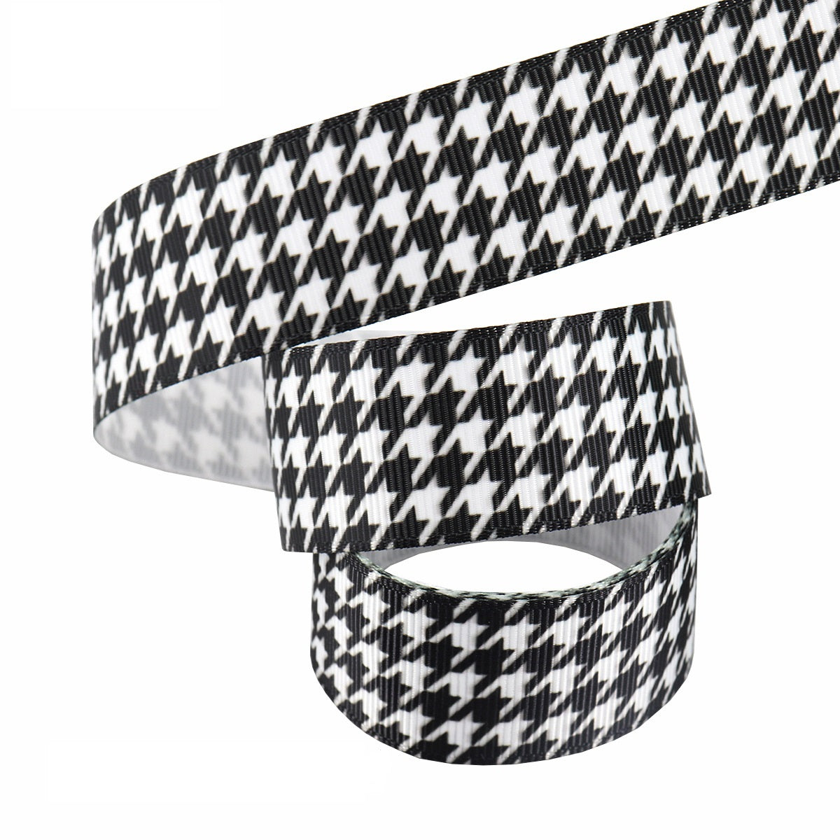 Black-and-white 25mm ribbon roll; houndstooth-style pattern with matching strip piece.