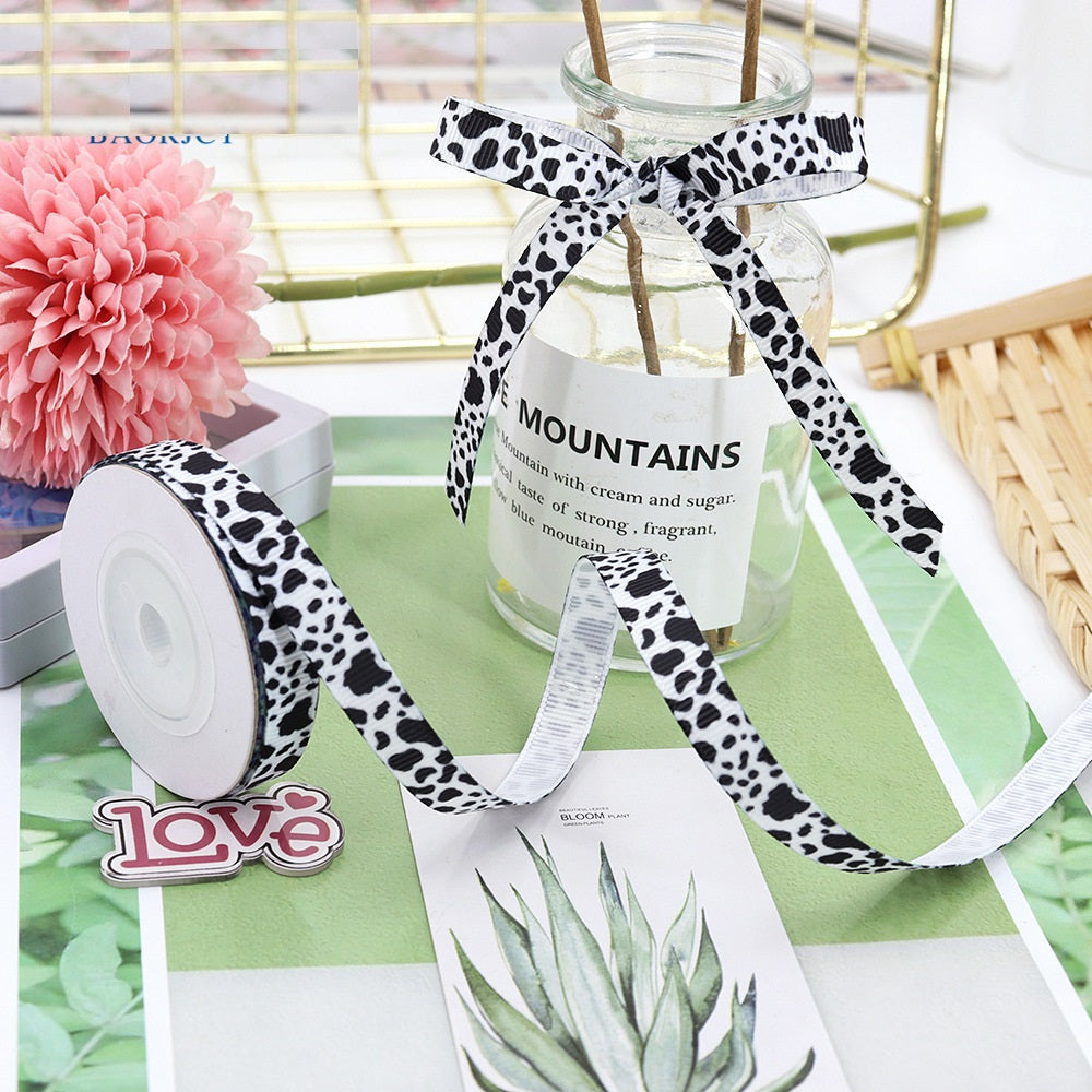 Black-and-white paw print ribbon, satin style, tied into a bow