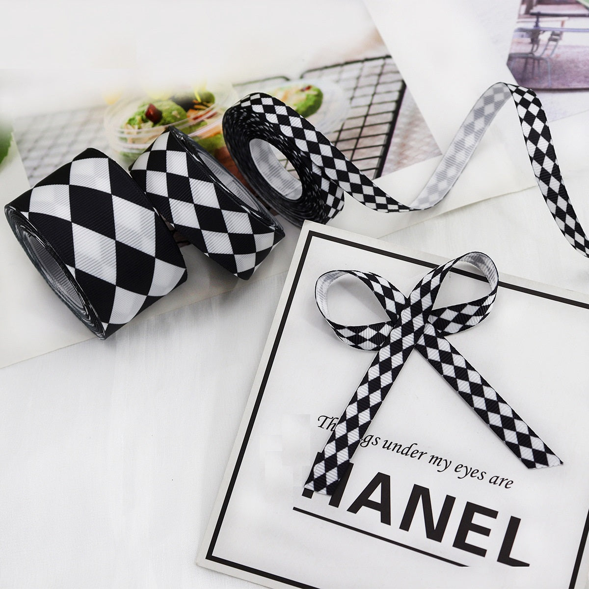 Black-and-white check ribbon lengths with a tied bow and two rolled pieces