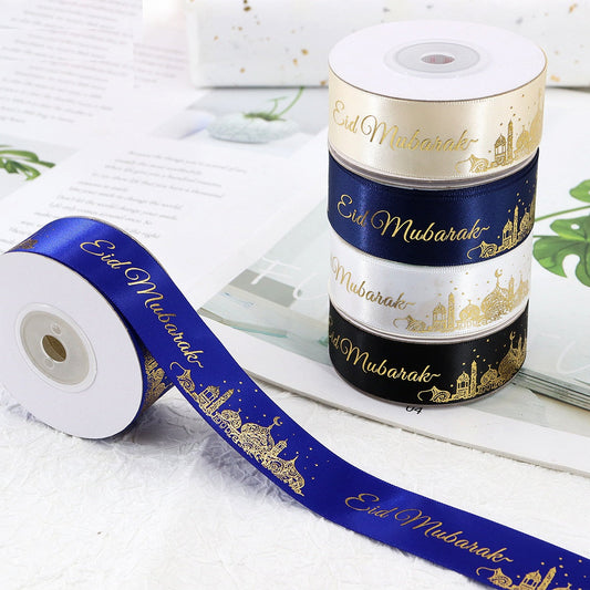 Spool of 1-inch ribbon in cream, dark blue, and black with gold Eid Mubarak text