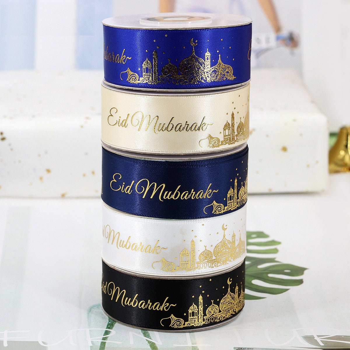 Stack of 1-inch satin ribbons: navy blue and cream bands with gold Eid Mubarak lettering