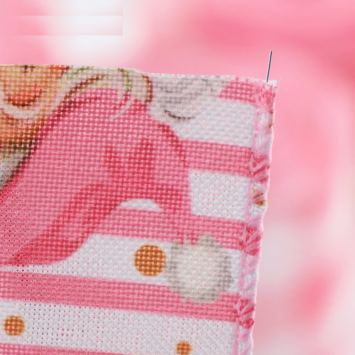 Close-up of pink wired hemming tape fabric edge and stitching, Christmas themed print