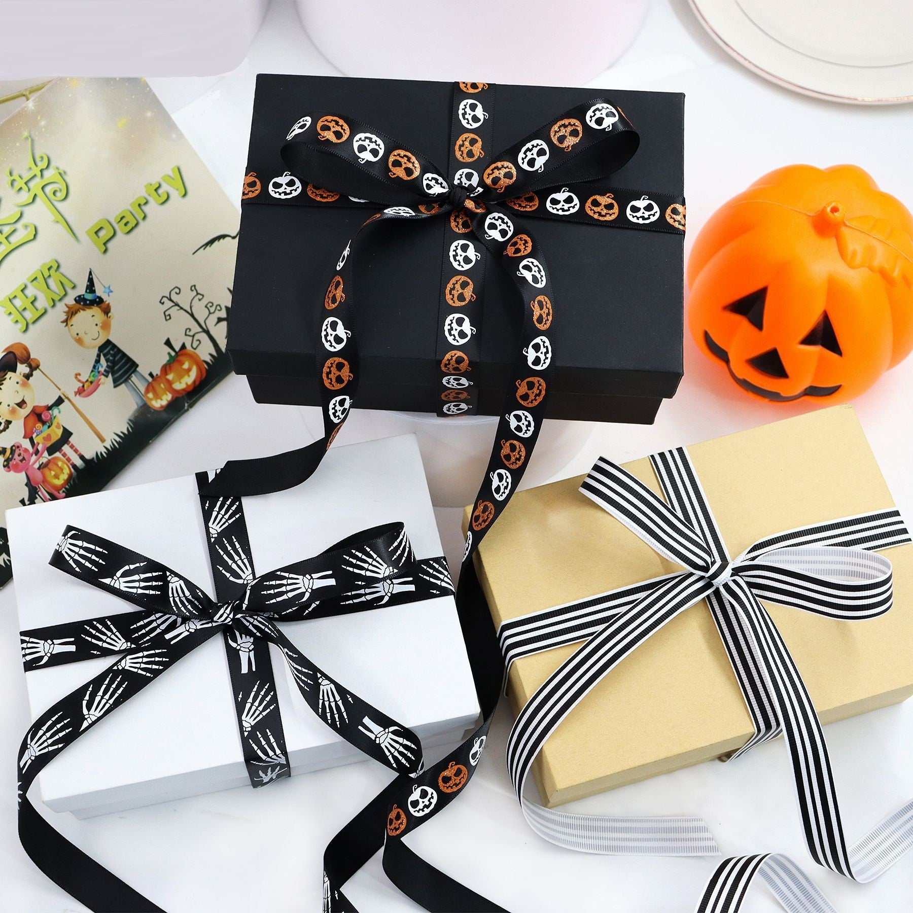 Black Halloween ribbon roll with repeating skull and pumpkin faces for gift bows.