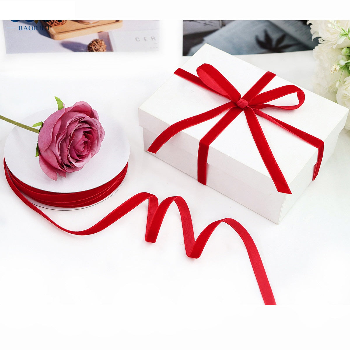 Single-sided velvet ribbon in deep red, loose loops extending from gift bow