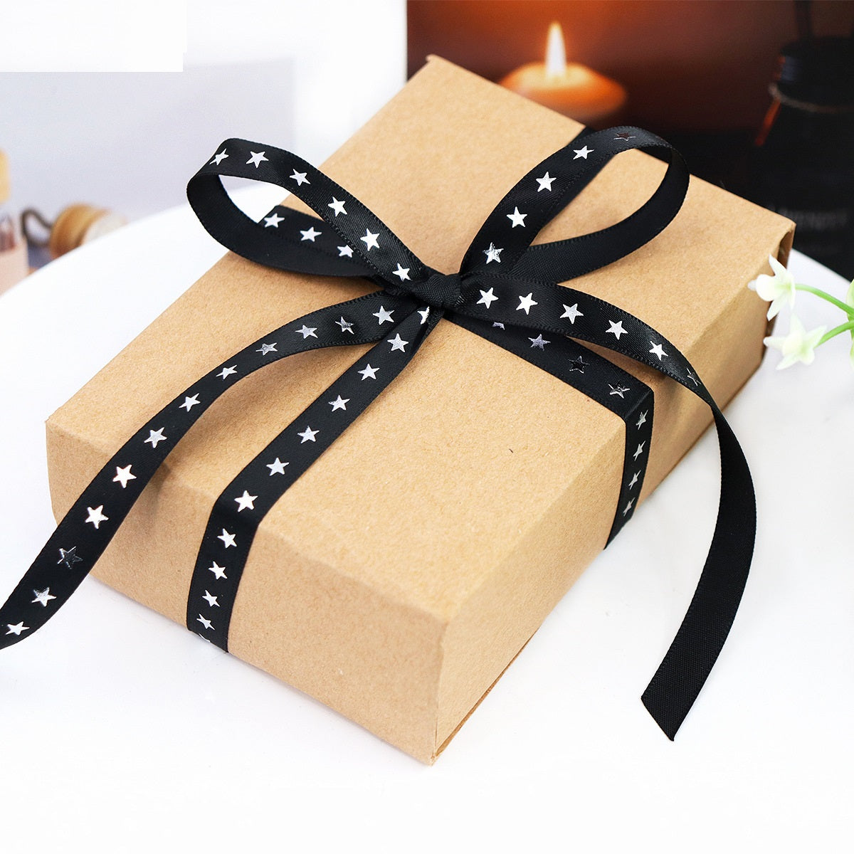 Star-print black ribbon with silver-foil stars tied around a gift package
