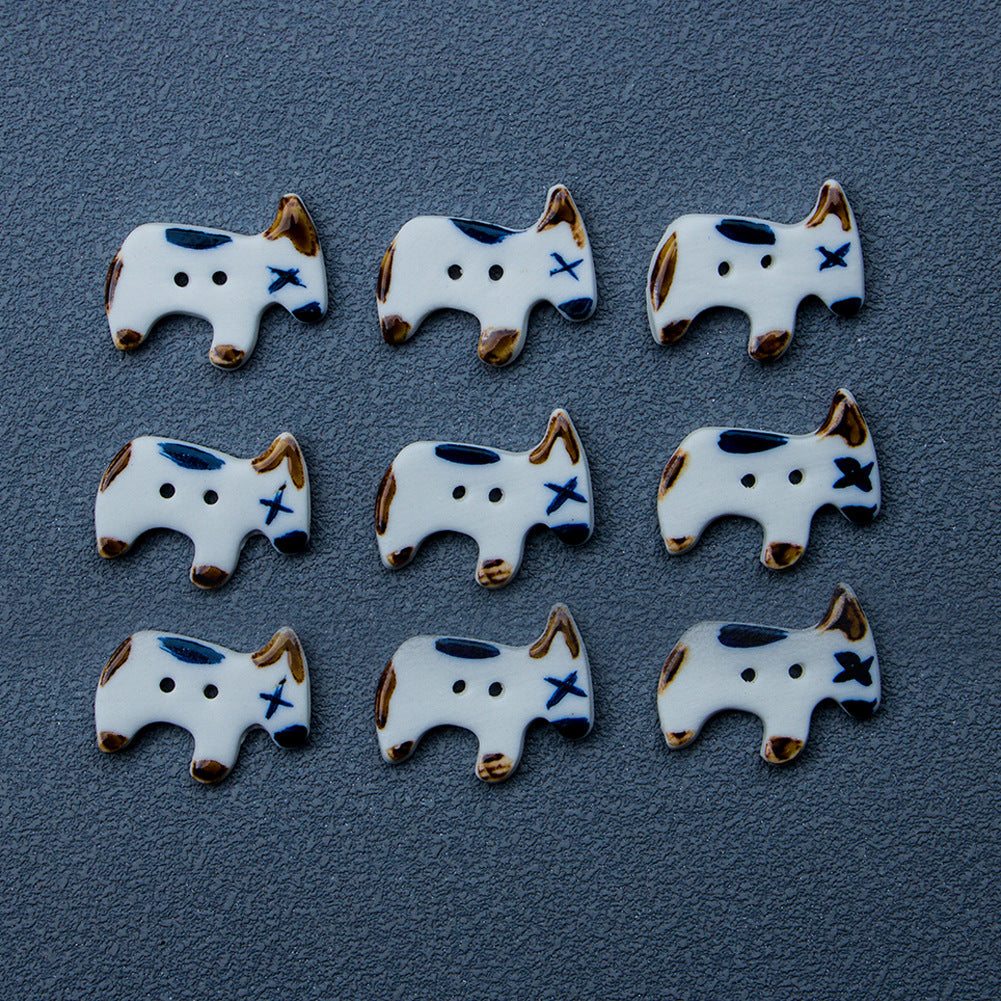 Four ceramic puppy dog buttons, white with blue nose and star accents, 2-hole design
