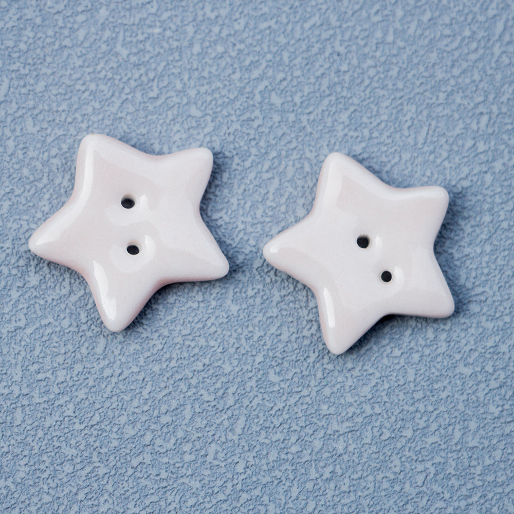 White ceramic star button with two holes, smooth glossy finish