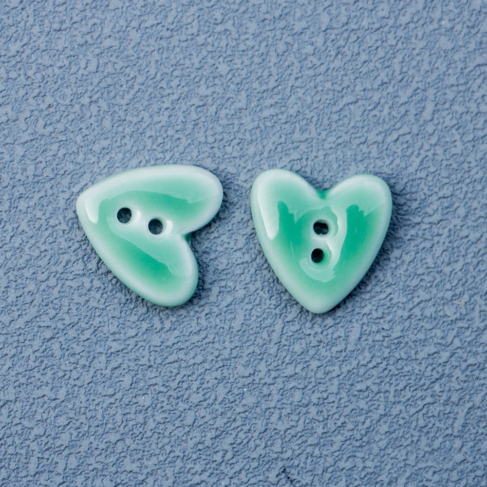 Light mint green heart-shaped 2-hole ceramic buttons pair with two holes