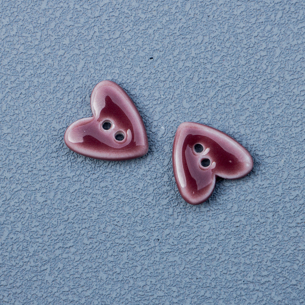 Purple/maroon heart-shaped 2-hole ceramic buttons pair with two holes