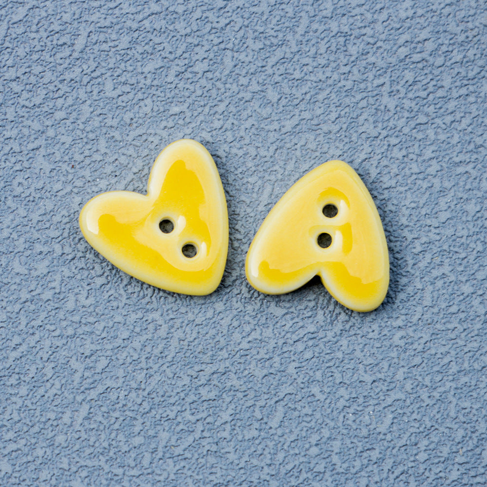 Yellow heart-shaped 2-hole ceramic buttons pair with two holes