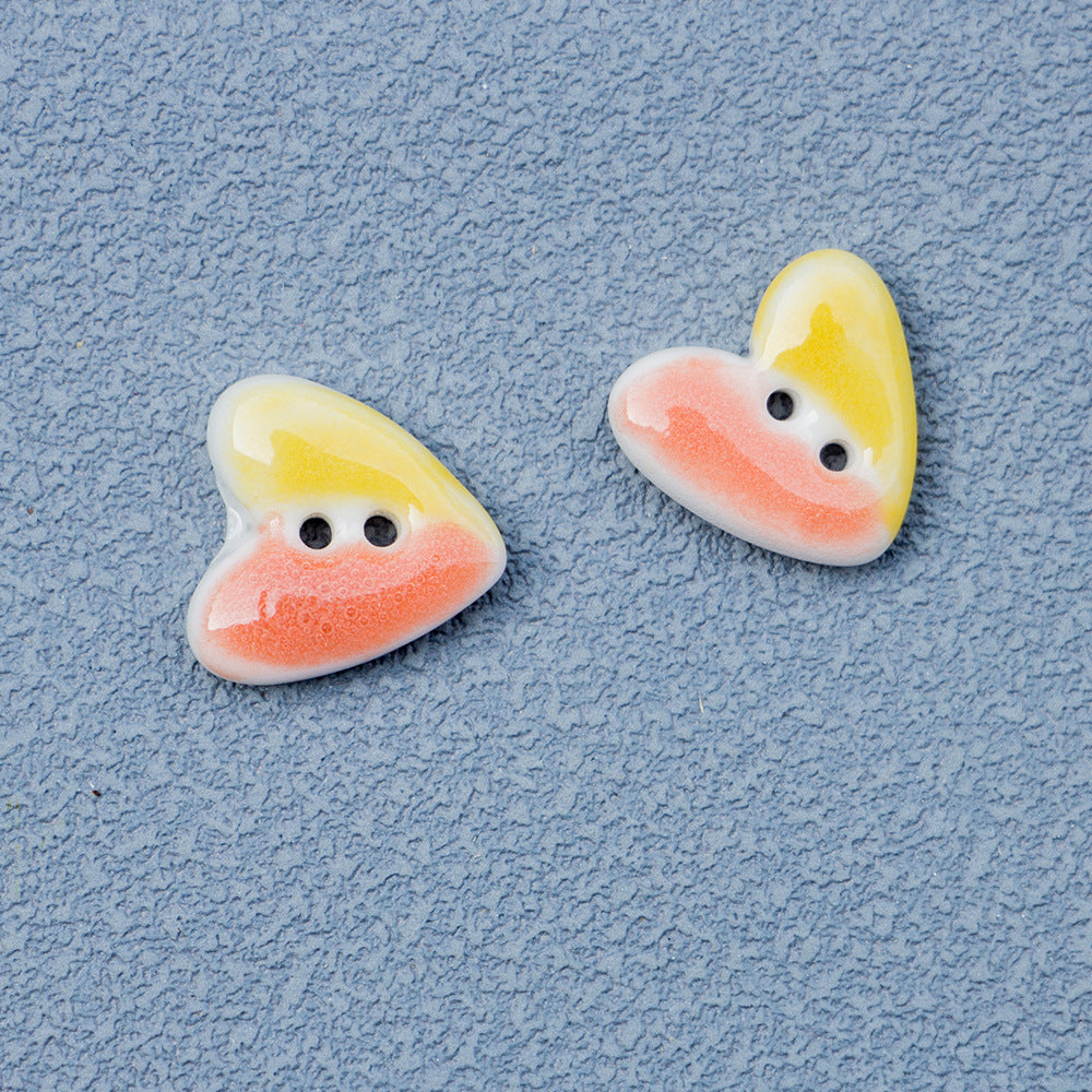 Pastel yellow and pink/orange heart-shaped 2-hole ceramic buttons pair