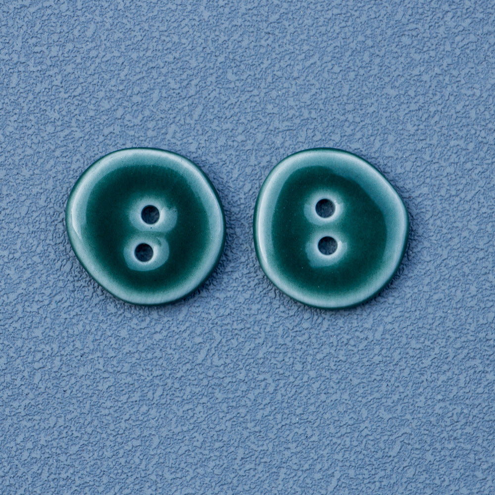 Two dark green ceramic round buttons, each with two holes