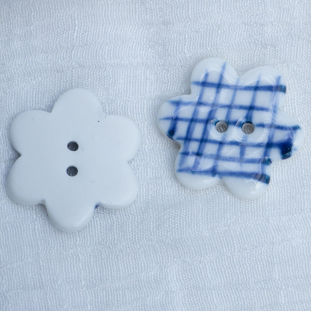 Porcelain flower buttons: one plain white, one blue plaid, both with 2 holes