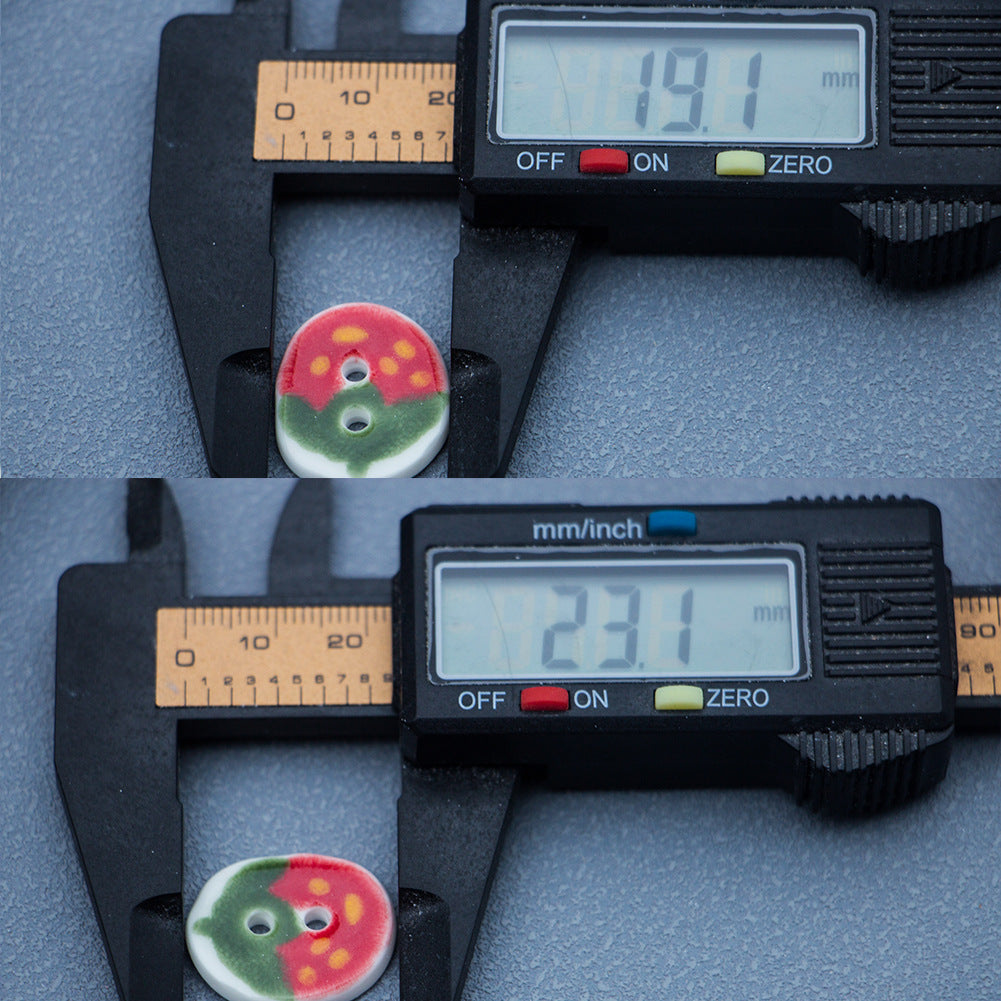 23mm oval ceramic button, red-green strawberry pattern, two holes; caliper measurement